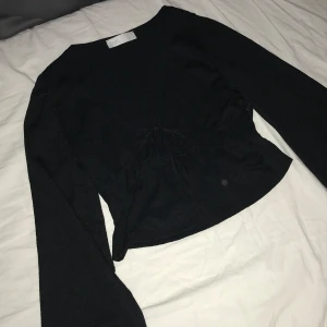 Svart blus - Svart blus med knytning där fram.
