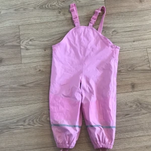 Regnbyxa - Ljusrosa regnbyxa. Använd fåtals gånger. Gosigt material inuti, som håller benen varm!