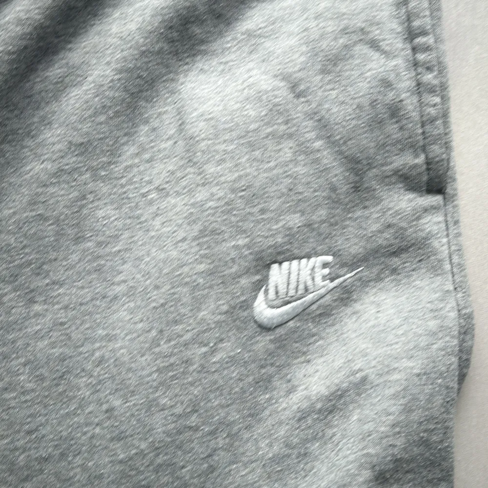 Säljer ett par grå mjukisbyxor från Nike i storlek M. De är superbekväma med elastisk midja och snörning för perfekt passform. Byxorna har en broderad Nike-logga på sidan och är gjorda av mjuk bomull, perfekt för chill dagar eller träning. 🩶. Jeans & Byxor.