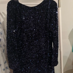 Mörkblå glittrig klänning - Mörkblå paljettklänning från H&M. Endast använd en gång. Låg rygg 