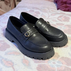 Svarta loafers med hjärtdetalj - Söta svarta loafers med hjärtdetalj, använda få gånger, säljer då om är för små för mig. Köpta som en 40 men är mer en 38 skulle jag säga. Innermått ca 23,9. 