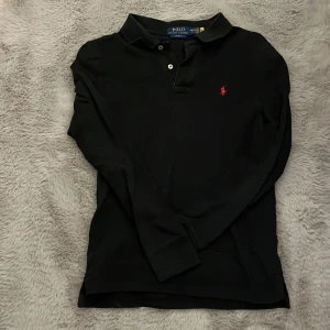 Ralph lauren långärmad pike - Hej säljer min svarta ralph lauren långärmad piké. Väldigt fint skick och sitter slim. 14-16 motsvarar ungefär XS/S, möjligt att gå ner i pris lite i snabb affär. Hör av er vid frågor