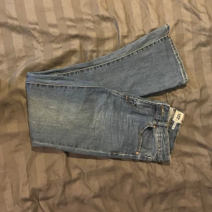 Blå jeans  - Säljer ett par klassiska jeans. De har en rak passform och är perfekta för en avslappnad stil. Jeansen har fem fickor och en knappgylf.