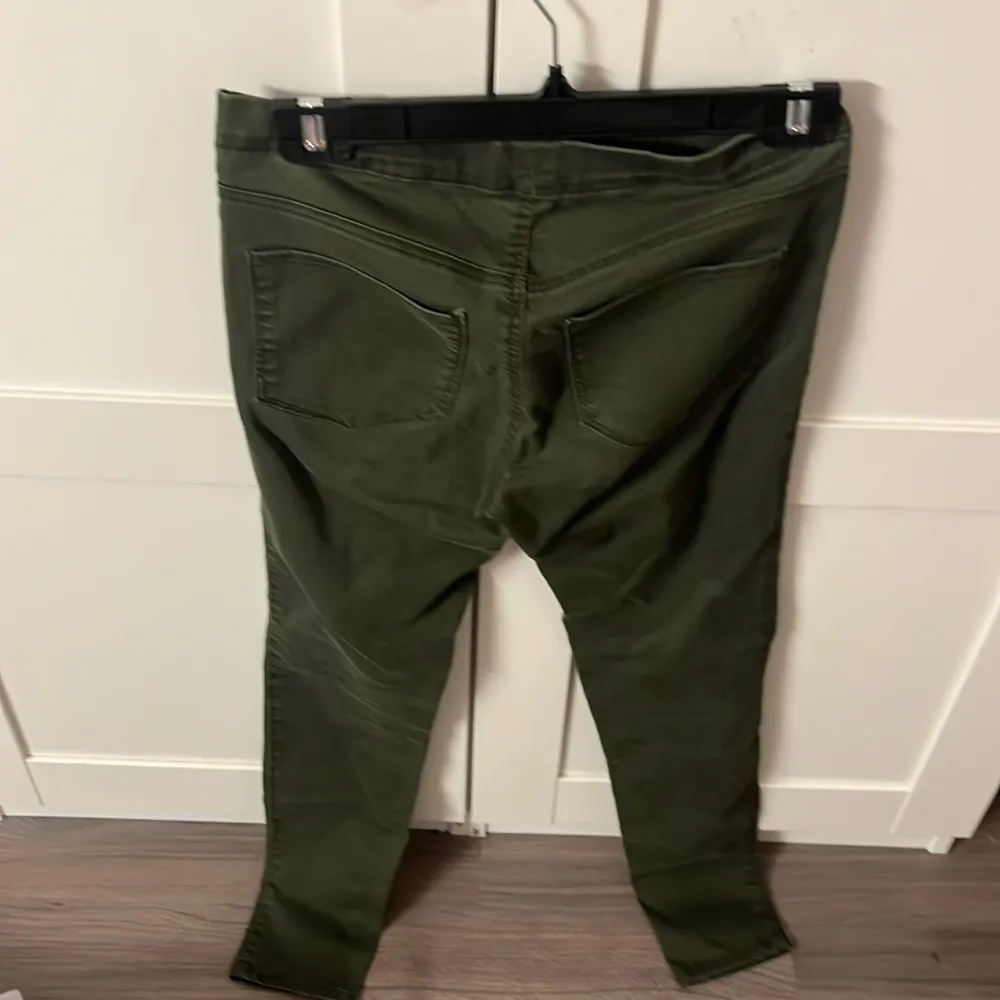 Snygga gröna byxor från H&M med en tight passform. Byxorna har en låg midja och är perfekta för en casual look. De har fickor både fram och bak, vilket ger en praktisk touch.. Farkut & Housut.