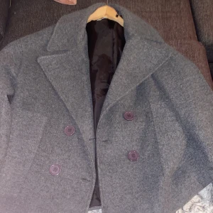 Grå kappa från Design by Si - Säljer en grå kappa från Design by Si.Den är i nytt skick, använd få gånger.Vid intresse skriv!