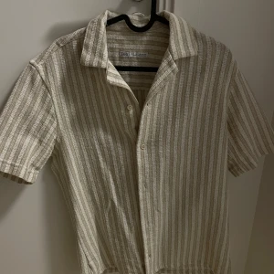 Beige och vit randig skjorta från Zara -  Säljer nu denna fina skjorta. Använd fåtal gånger så är i super bra skick. Storlek S. Hör av er om ni vill ha fler bilder eller funderingar