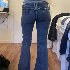 Unika lågmidjade jeans - Sååå coola jeans med unika detaljer. De är i mycket bra skick. Modellen är 159 cm. Innerbenslängd 78 cm, midjemått 37 cm. Jeansen är i ganska  stretchigt material och utsydda.