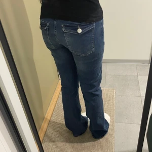 Blå bootcut jeans - Snygga blå bootcut jeans med knappar där bak