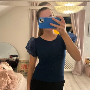 Mörkblå topp med puffärmar - Säljer en stilren mörkblå topp med korta puffärmar. Perfekt för en trendig look. Passar bra till både jeans och kjol.