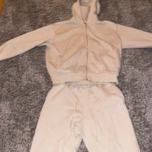 Beige tracksuit  från booho - Säljer en beige hoodie och matchande byxor från boohoo. Hoodien har dragkedja och byxorna har snörning i midjan. Perfekt för en avslappnad stil. Priset kan diskuteras 