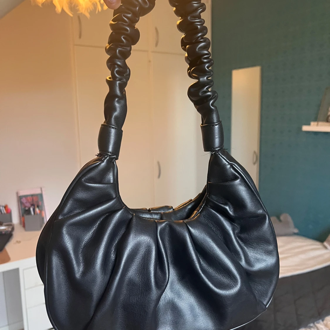 Svart axelväska i syntet