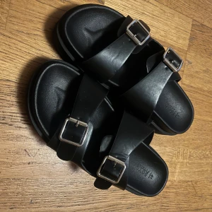 Svarta sandaler med spännen - Snygga svarta sandaler med dubbla remmar och justerbara spännen i silver. Perfekta för en avslappnad stil.