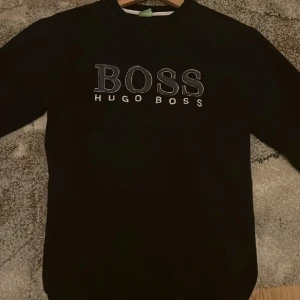 Hugo Boss tröja - Snygg svart tröja från Hugo Boss med broderad logga på bröstet och ärmen. Köpte hoodien från Hugo boss, använt Max 3 gånger, tröjan är stilren och jätte bekväm, pris kan diskuteras