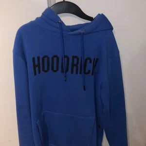 Blå hoodie och byxor från Hoodrich - Säljer en blå hoodie och matchande byxor från Hoodrich. Hoodien har en stor ficka framtill och justerbar dragsko i huvan. Byxorna har elastisk midja och muddar vid bensluten. Perfekt för en avslappnad stil.