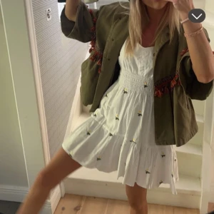 Vit klänning med blommor  - Vit klänning med gula blommor, använd fåtal gånger och är i bra skick!