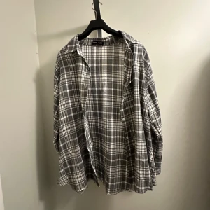 Grå och vit rutig skjorta - En snygg grå och vit rutig skjorta från Shein i storlek M. Den har en avslappnad passform, långärmad och har knappar framtill. Oanvänd!