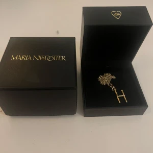 Bokstavshalsband Maria Nilsdotter H  - Wonky letter guld halsband från Maria Nilsdotter, köptes i september 2023 men har inte använts så mycket, tecken på oxidering finns och förlorat lite färg men den är fortfarande guldig! !LÄNGDEN ÄR 45!