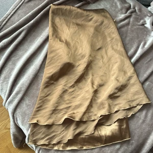 Brons långkjol - Obs, lång kjol som är bronsfärgad, ser guldig ut på kameran men är ej det irl. Den är även vikt på bild!