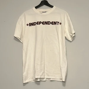 Vit t-shirt från Independent - Vit t-shirt från Independent med tryck fram och stort tryck bak. 