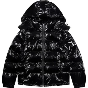 Svart pufferjacka från Trapstar - Snygg svart pufferjacka från Trapstar med glansig finish och dragkedja framtill. Jackan har en huva och är perfekt för kyligare väder. Den har en modern look med märkets logga diskret placerad. Skittjock asså den håller en varm fr