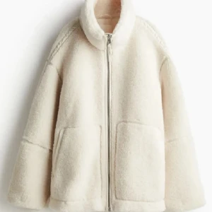 Beige teddyjacka med dragkedja - Populär Mysig beige teddyjacka med dragkedja och hög krage. Perfekt för kyliga dagar med sin fluffiga och varma design. Jackan har två stora fickor framtill och en avslappnad passform. Säljer pågrund av att den är för stor