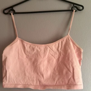 Rosa croppad linnetopp - Söt rosa croppad linnetopp med smala axelband. Perfekt för varma sommardagar eller som ett lager under en tröja. Enkel och stilren design som passar till det mesta. Fläck under armarna ej jätte synlig. OBS! Varan finns på andra säljsidor också så skynda att fynda innan någon annan gör de!💕