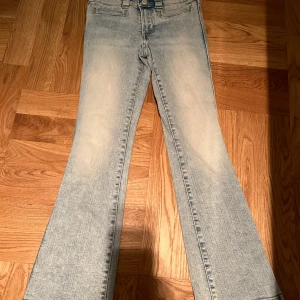 Ljusblå bootcut jeans från H&M - Säljer ett par ljusblå bootcut jeans från H&M i storlek 9-10 år. De har en snygg tvättad look och är högmidjade för en bekväm passform. Perfekta för vardag🥰