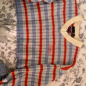 Randig tröja från Kickers - Säljer en cool randig tröja från Kickers i blått, rött och vitt. Den har en v-ringad krage och är perfekt för både vår och höst. Tröjan är i bra skick och passar perfekt för en avslappnad stil. Perfekt för dig som vill sticka ut lite! 🌟