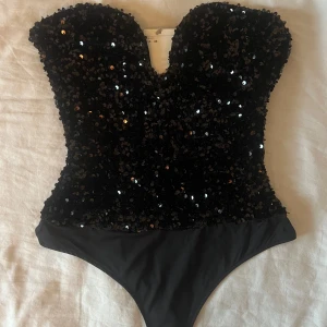H&m paljett body - Helt slutsåld paljett body från h&m. Passar perfekt nu inför jul/nyår. Storlek xs. Ny med prislappen kvar. Skriv om ni undrar något!