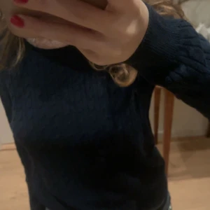 Mörkblå stickad tröja - Säljer en stilren mörkblå stickad tröja med långärmad design.