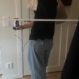 Blå loose jeans från Carhartt - Säljer ett par snygga blå jeans från Carhartt i bra skick. De har en loose passform och är perfekta för en avslappnad stil. Storlek xs unisex, passar non som är runt 160 lång. Jeansen har en klassisk femficksdesign och Carhartt-loggan på bakfickan. Perfekta för både vardag och chillhäng! Orginalpriset är 1600, kom med prisförslag! ☺️