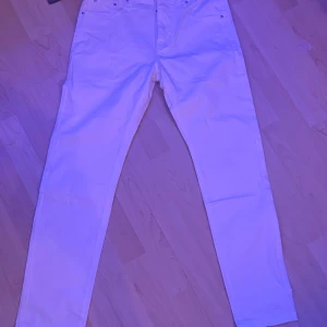 Vita jeansbyxor från Amiri - Säljer ett par snygga vita jeansbyxor från Amiri. De har en klassisk femficksdesign och en knappgylf. Perfekta för både vardag och fest! Passar till alla säsonger och är i mycket bra skick.  Vet ej priset på dom så ge mig ett pris.