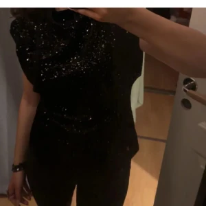 Svart glittrig topp från Zara - Snygg topp från Zara helt perfekt till nyår i ett mycket bra skick, den är endast använd en gång och passar även S 🙏🏽🙏🏽🙏🏽 köpt för 500 kr, skriv vid frågor eller fler bilder💕