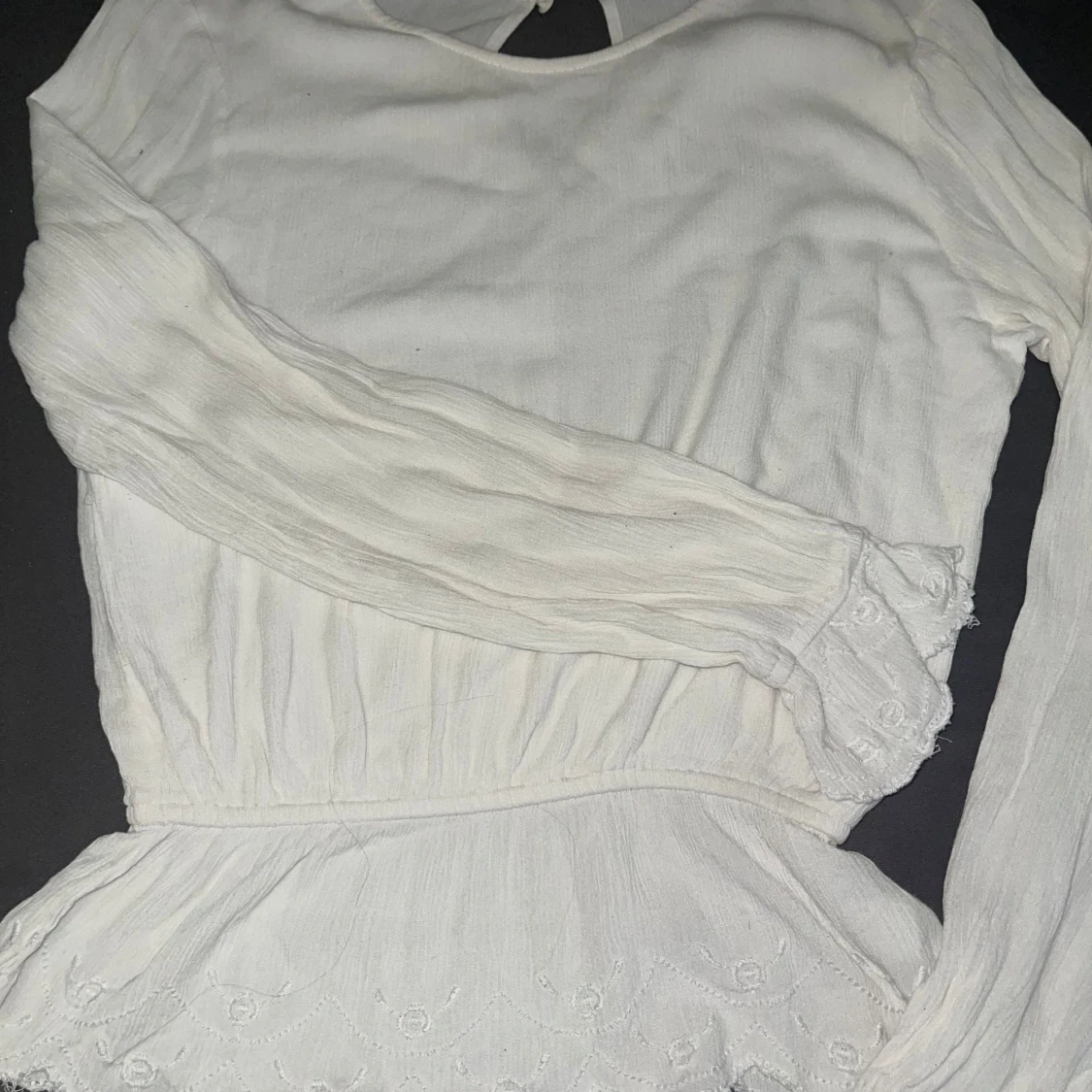 vit blus med volanger och små blomdetaljer