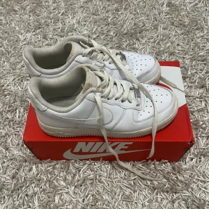 Nike Air Force 1 - Säljer ett par klassiska vita Nike Air Force sneakers i bra skick. De har en stilren design med snörning och är perfekta för vardagsbruk. Skorna är bekväma och passar till de flesta outfits. Perfekta för både vår och sommar!