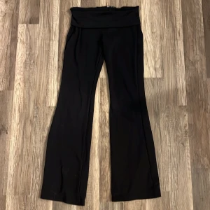 Svarta yoga pants med låg midja - Snygga svarta yoga pants med låg midja och bootcut-stil. Perfekta för en stilren look. Tillverkade i ett mjukt och bekvämt material.