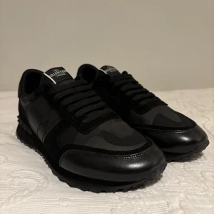 Valentino Garavani rockrunners - Snygga svarta rockrunners sneakers från Valentino Garavani. Skorna har en kombination av skinn och mocka med svarta snören och en robust sula. Perfekta för en trendig look. Alla accessoarer är inkluderade, inklusive sko lådan.