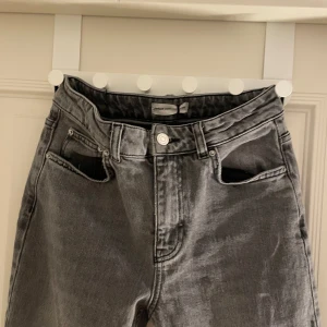 Grå jeansbyxor - Snygga grå jeansbyxor med en klassisk design. De har en rak passform och är perfekta för en avslappnad stil. Byxorna har fem fickor och en knappgylf.