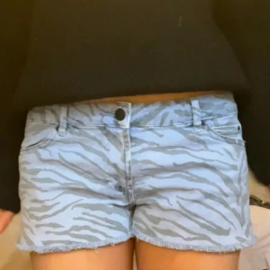 Zebramönstrade jeansshorts  - Snygga blå jeansshorts med zebramönster. Lågmidjade med avklippt kant