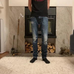 Blå jeans från Replay - Feta ovanliga jeans från Replay med slitna detaljer och en klassisk femficksdesign. Skönt hål under knät men annars väldigt bra skick. Storlek 29:34, men dem flesta passar dem bra på. Modellen är 179.