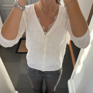 Vit stickad kofta  - Vit trekvartsärmad stickad kofta med blommönster från Mango i storlek M, skulle säga att den även passar S. Fint skick. Använd gärna köp nu!