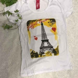Tjejer t-shirt  - Säljer en vit t-shirt med olika tryck. En har Eiffeltornet och hjärtan, en annan har texten 'Newlook' med ett färgglatt motiv, och den sista har texten 'May the bridges I burn light the way'. Perfekt för en casual look!   69kr/st . Helt ny 