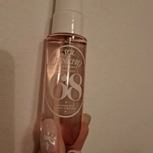 Sol de Janeiro Brazilian Crush Cheirosa 68 - En doftmist från Sol de Janeiro med noter av brazilian jasmine, pink dragonfruit och ocean air. Perfekt för att fånga känslan av Rios trädgårdar vid havet. Flaskan är genomskinlig med en vit spraykork och har en elegant design med siffran 68 i fokus.