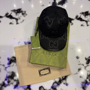 Gucci Jumbo Black Hat Keps - Svart gucci jumbo keps säljes. Den är i storlek L och som ni ser i väldigt bra skick. Den är äkta men har använt den för mycket och vill gärna ha pengar till annat. Normal i storlek. Kan justeras så att den passar M. Tillbehör medföljer.