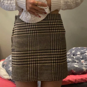 Rutig kjol från H&M - Snygg rutig kjol från H&M i svart och beige. Kjolen har en klassisk passform och är jätteskön och även superfin att ha på hösten med strumpbyxor!