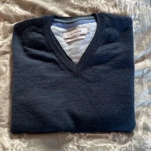 Mörkblå merinoull tröja  - Snygg mörkblå tröja från Coney Island med v-ringad design. Tröjan är i ett mjukt material som känns skönt mot huden. Den är storlek L men har sjunkit i storleken lite.