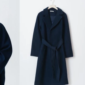 Mörkblå kappa med bälte - Elegant mörkblå kappa med knytbälte i midjan. Den har kvar prislapp, aldrig andvänd 