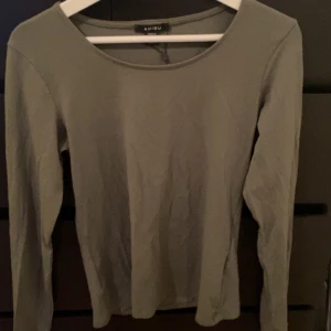 Grön långärmad tröja från Amisu - Säljer en stilren grön långärmad tröja från Amisu. Perfekt för en avslappnad look. Tröjan har en rund halsringning och är tillverkad i ett mjukt material.