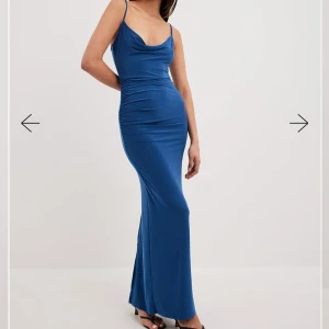 Blå långklänning med smala axelband - Blå långklänning med smala axelband och draperad detalj framtill. Endast testad, lappen finns kvar. Perfekt till balen eller annat tillfälle! Storlek xxs men passar också xs
