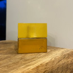 Zen Shiseido Eau de Parfum 30ml - Zen Eau de Parfum från Shiseido i en elegant guldfärgad flaska. Doften har toppnoter av grapefrukt, ananas och bergamott, med hjärtnoter av fresia och röd äpple. Basnoterna inkluderar patchouli och cederträ. Perfekt för den som älskar en fräsch och blommig doft med en träig bas. Det är lite mer än hälften kvar och nypris ligger på 600kr💛